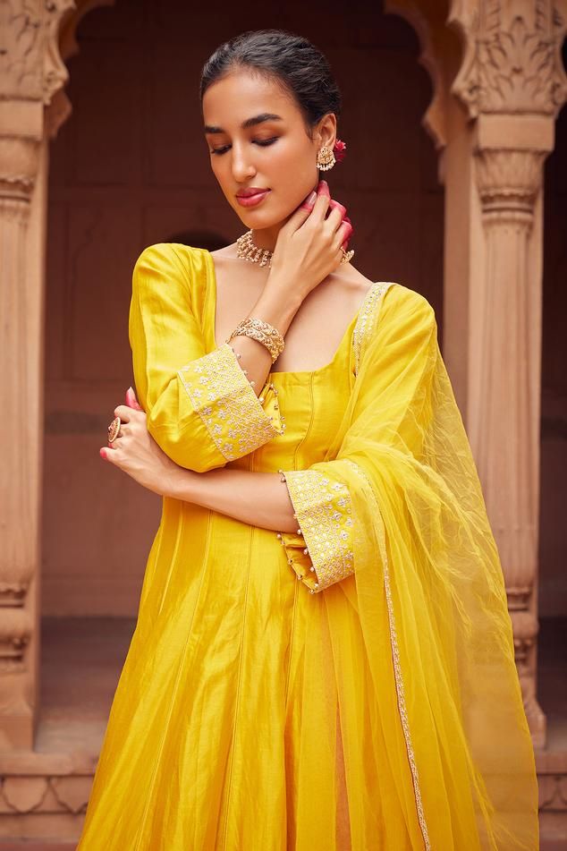 Yellow three fourth sleeves anarkali with floral embroidery on sleeves and kurta hem. Paired with plain churidar and embroidered border dupatta.
Components: 3
Pattern: Embroidery
Type Of Work: Floral
Neckline: Round
Sleeve Type: Three Fourth
Fabric: Chanderi Silk, Tulle
Color: Yellow
Other Details: 
Tassels on dupatta corners
Ghungroo tassels on sleeves hem
Length:
Anarkali: 49 inches
Churidar: 46 inches
Closure:
Anarkali: Back tassel tie-up
Note: The jewellery worn by the model is not for sale Anarkali Dress With Embroidered Border For Festivals, Anarkali Dress With Embroidered Border For Eid, Anarkali Dress With Embroidered Border For Wedding, Eid Anarkali Dress With Embroidered Border, Anarkali Wedding Dress With Embroidered Border, Chanderi Salwar Kameez With Embroidered Border And Long Sleeves, Navratri Long Sleeve Salwar Kameez With Embroidered Border, Festive Straight Kurta Dress With Embroidered Border, Bollywood Style Festive Dress With Embroidered Border