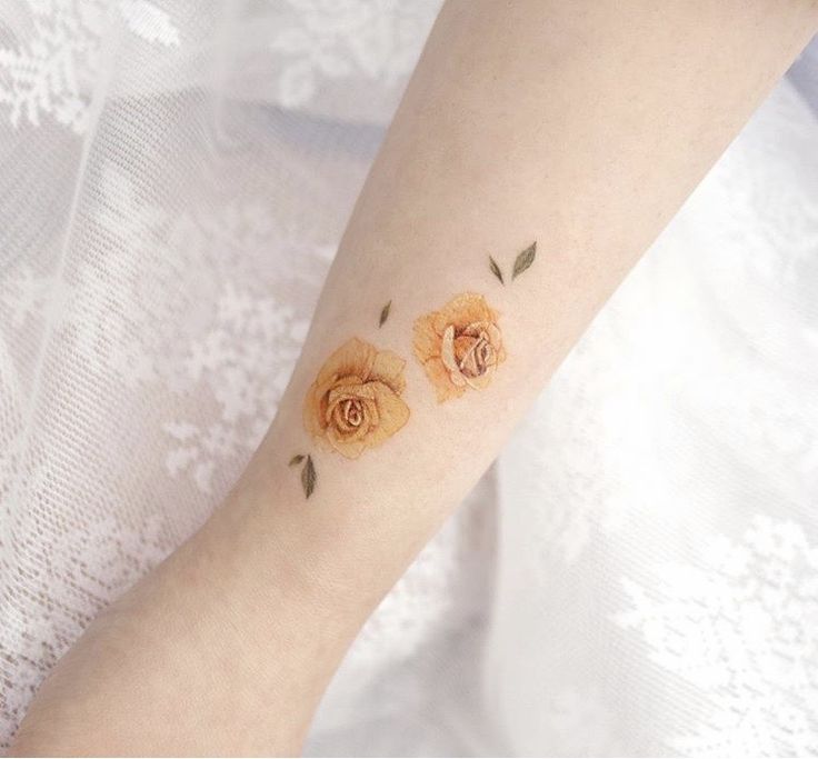 a woman's arm with two roses on it