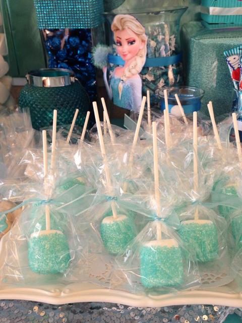 there are many green candies wrapped in plastic and sitting on a tray with toothpicks