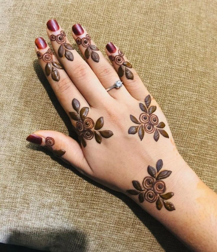 a woman's hand with henna tattoos on it