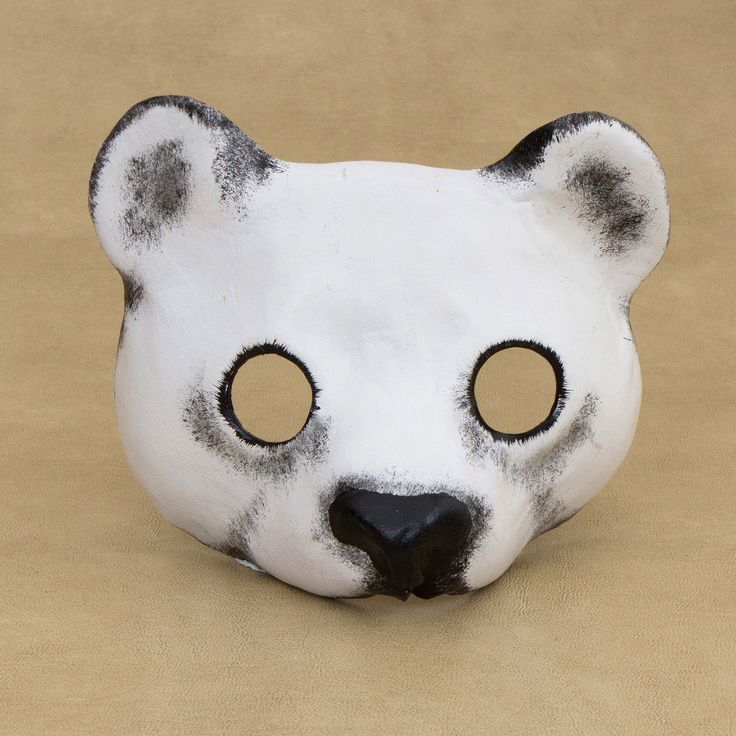 a white mask with black spots on it's face and eyes are shaped to look like a polar bear