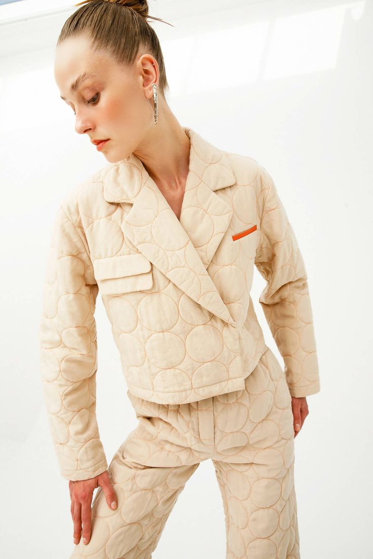 Colour: beige with contrasting threads Fabric: Main fabric is 100% vegan silk, lining is 100% cotton Opening system: hidden snaps Details: beige with contrasting thread stitches, quilted vegan silk, notched lapels, front hidden snap fastening, long sleeves, straight hem, cropped, apple leather imitation handkerchief pocket and flap pockets. Beige Cotton Blazer With Suit Collar, Quilted Beige Cotton Outerwear, Beige Quilted Cotton Outerwear, Beige Cotton Long Sleeve Blazer, Quilted Beige Outerwear For Spring, Cream Quilted Outerwear For Spring, Beige Long Sleeve Quilted Jacket With Pockets, Quilted Beige Spring Outerwear, Cream Outerwear With Lapel Collar And Patch Pockets