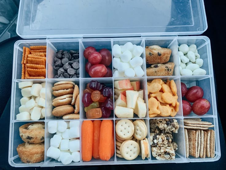 a plastic container filled with lots of different types of snacks and crackers in it