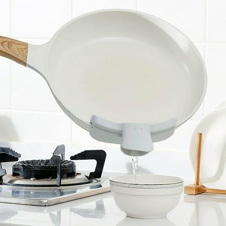 a frying pan on top of a stove next to other cooking utensils