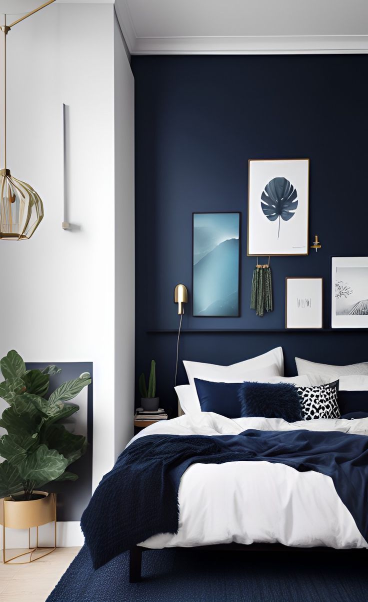 a bedroom with dark blue walls, white bedding and art on the wall above it