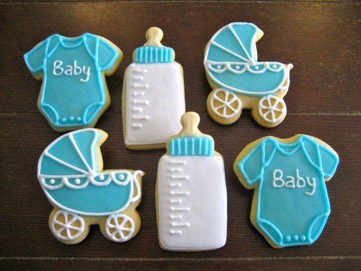 baby shower cookies decorated with blue icing and white icing on a wooden table