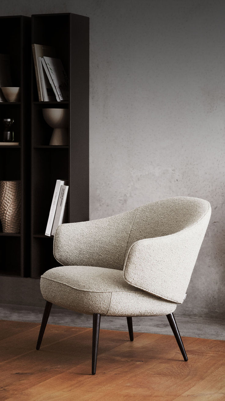 a chair sitting on top of a hard wood floor next to a book shelf filled with books