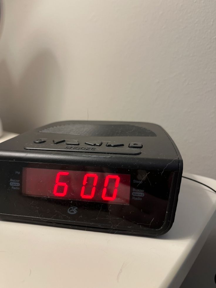 an alarm clock sitting on top of a white table