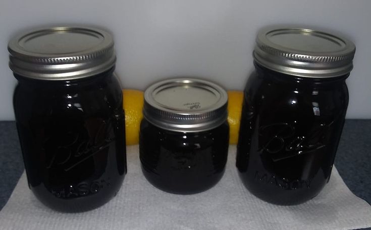 three mason jars are lined up next to each other with lemons on the side