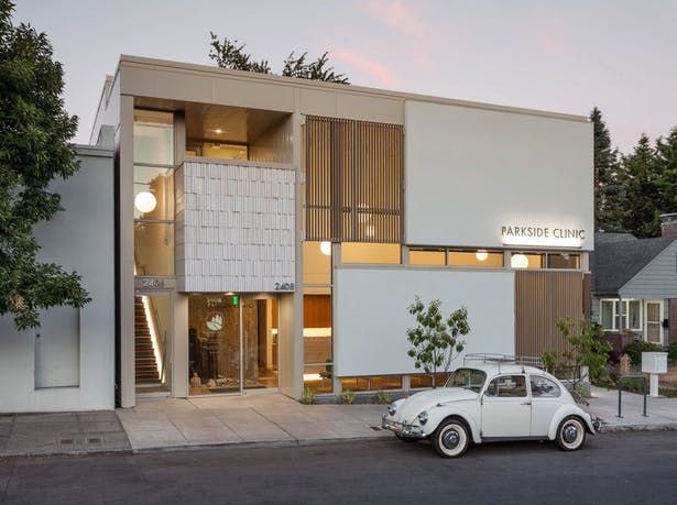 an old white car parked in front of a building