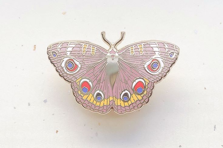 a pink butterfly sitting on top of a white surface