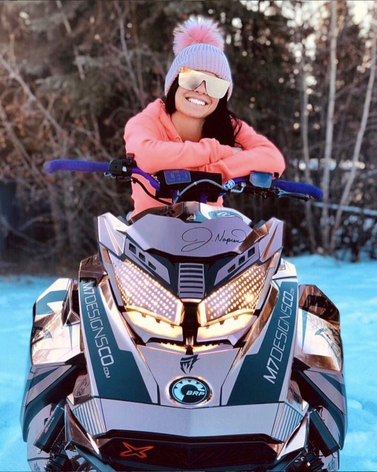 a woman riding on the back of a snowmobile