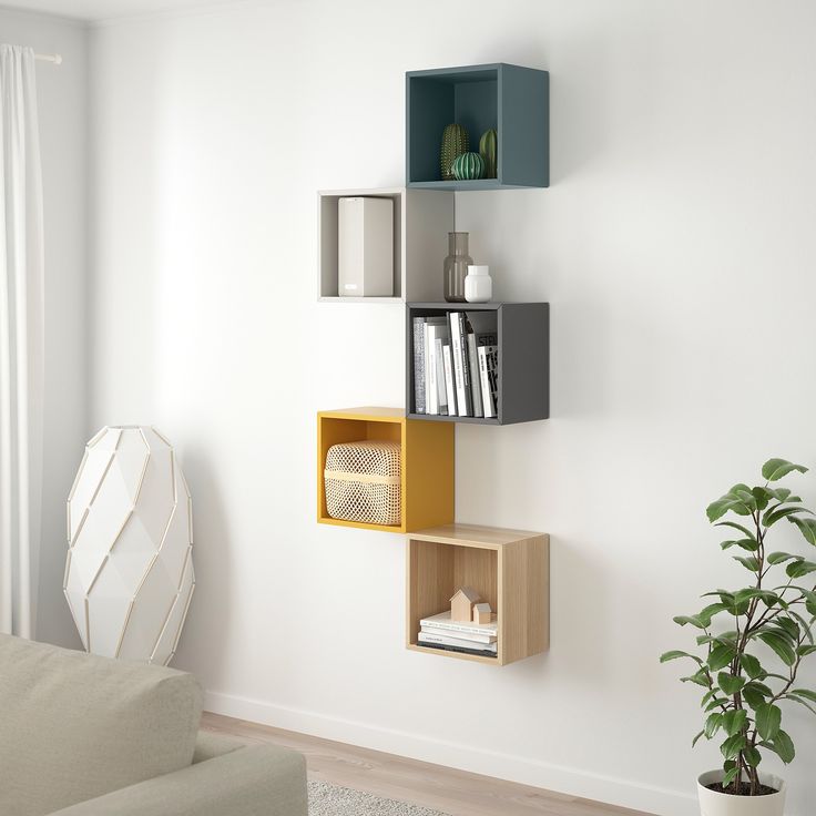 a living room filled with furniture and a plant in front of the wall mounted bookshelf