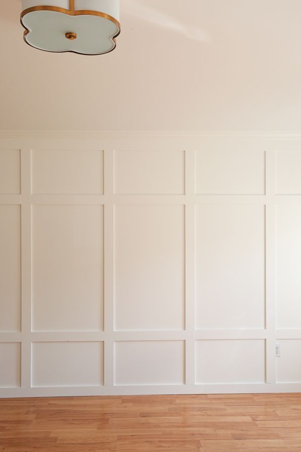 an empty room with white walls and wood flooring is pictured in this image, there are two lamps on the ceiling