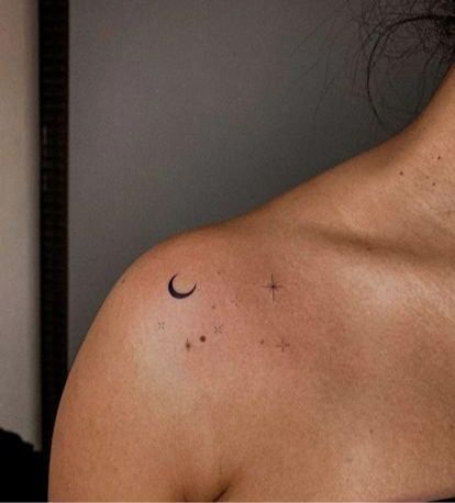 a woman with a cross and crescent tattoo on her back shoulder is looking at the camera