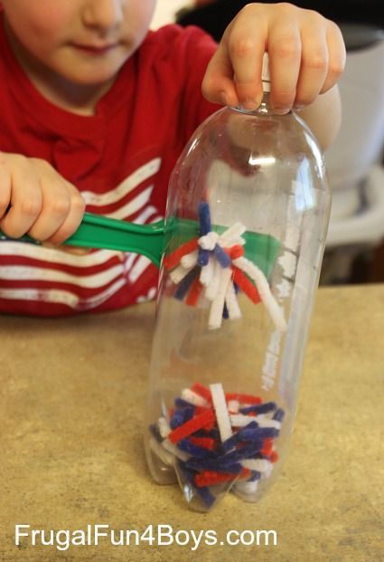 a young child is playing with some sand in a glass bottle that has been filled with beads