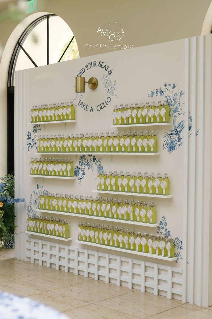 there is a wall display with many green items on the shelves and flowers in vases