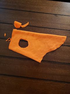 an orange towel is laying on top of a wooden table with a hole in it