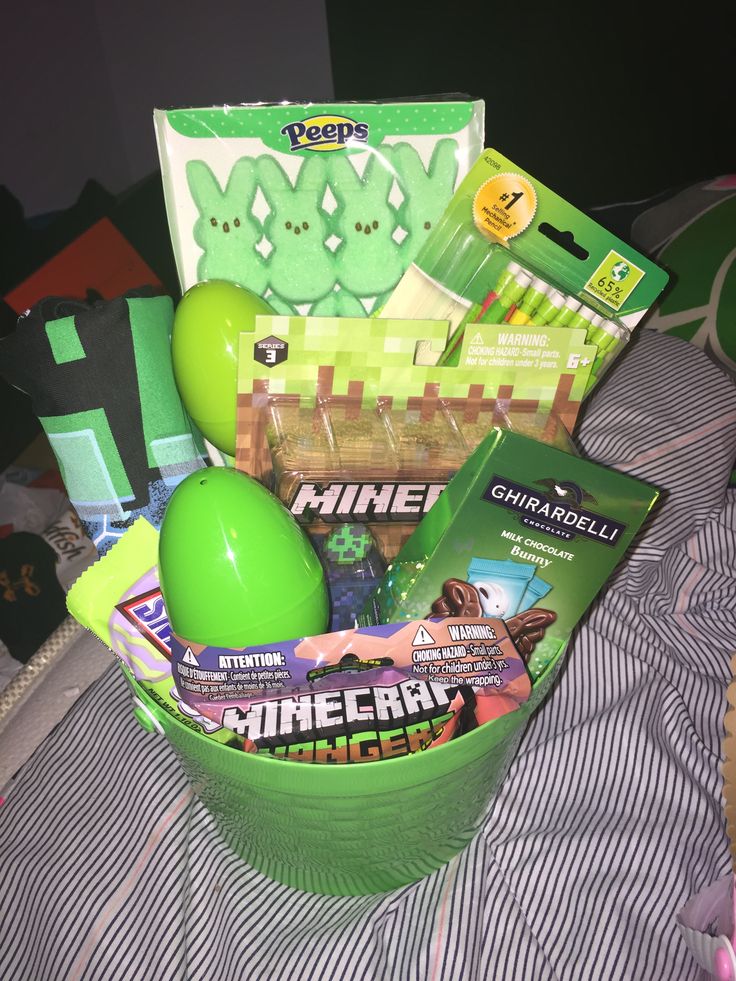 a green basket filled with toys and other items on top of a bed next to a pillow