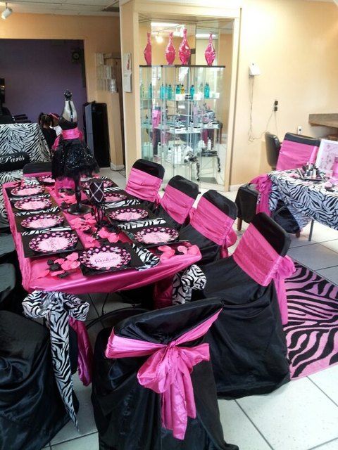 a room filled with lots of black and pink tables covered in zebra print table cloths