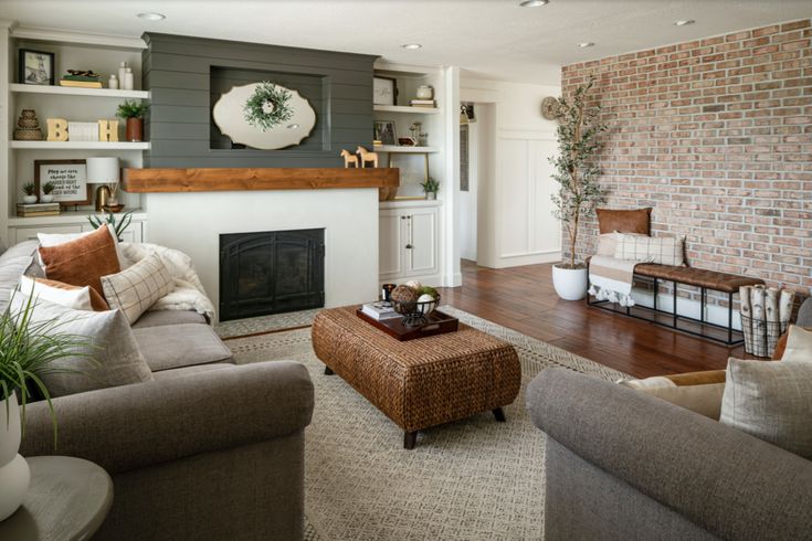 a living room filled with furniture and a fire place in front of a brick wall