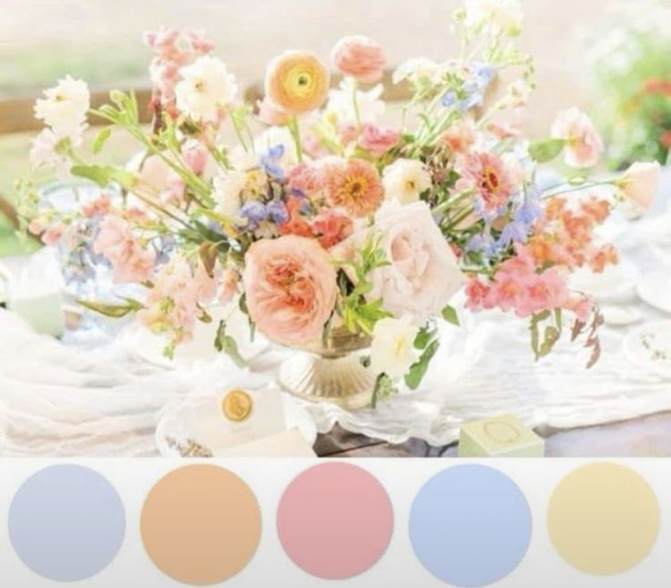 a vase filled with flowers sitting on top of a table next to plates and utensils