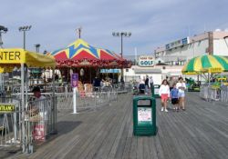 the boardwalk is crowded with people and umbrellas