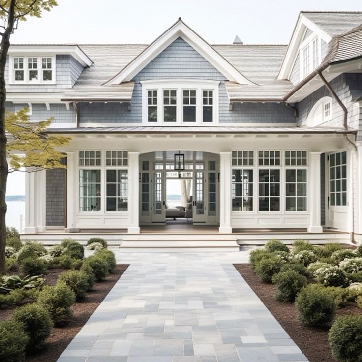 a large house with white trim and gray shingles on the front door is shown