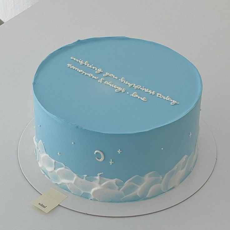 there is a blue cake with white frosting on the top and writing on it