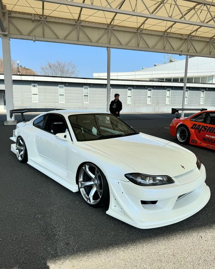 two white cars parked next to each other in a parking lot