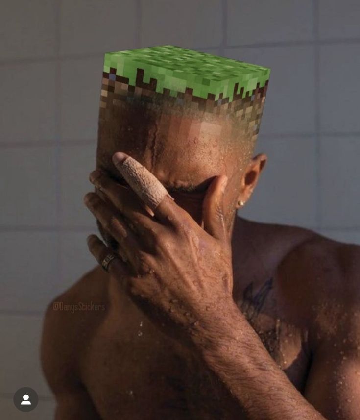 a shirtless man holding his face in front of his face with a green block on it