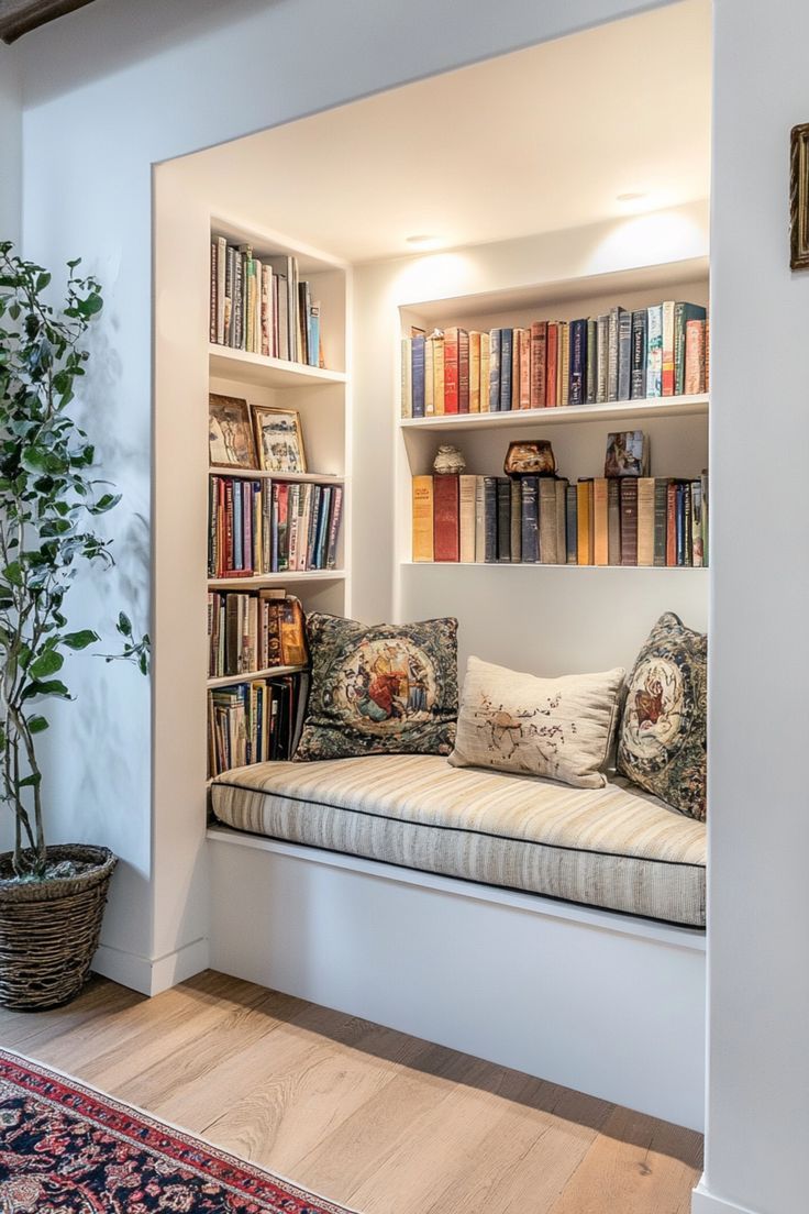 a window seat with bookshelves in the background and a potted plant next to it