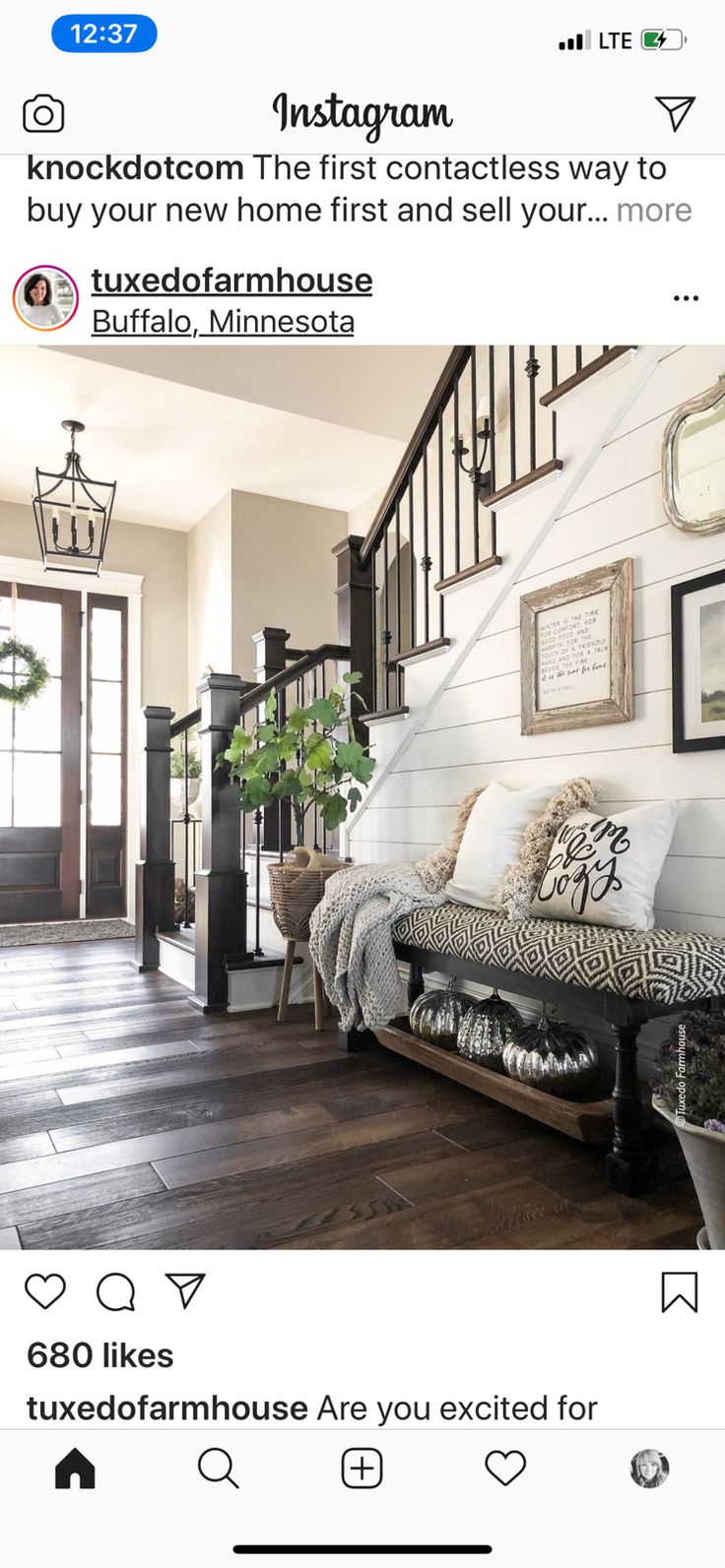 a living room filled with furniture next to a stair case and potted plant on top of a hard wood floor