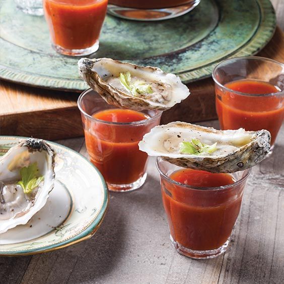 three glasses filled with different types of food on top of a wooden table next to plates