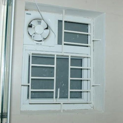 an air conditioner mounted to the side of a wall next to a window with bars on it