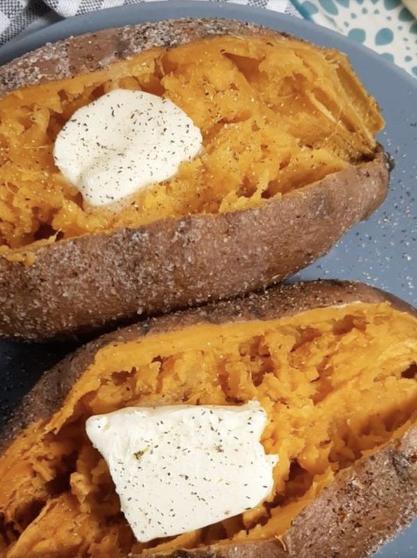 two baked sweet potatoes with butter on top