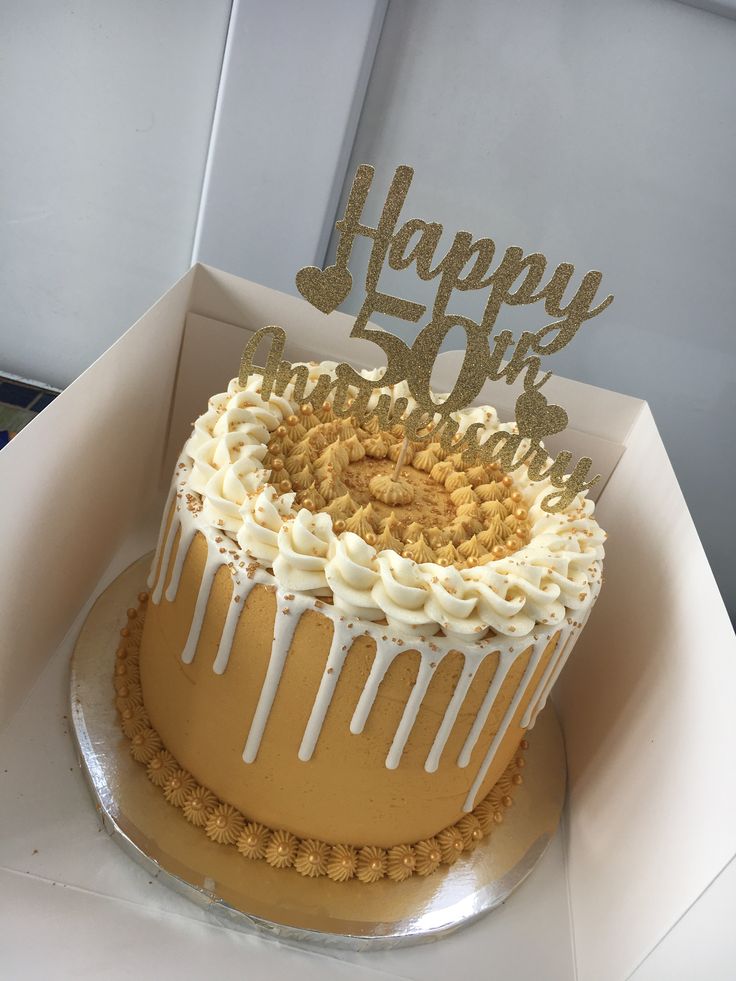 a 50th birthday cake with white frosting and sprinkles in a box