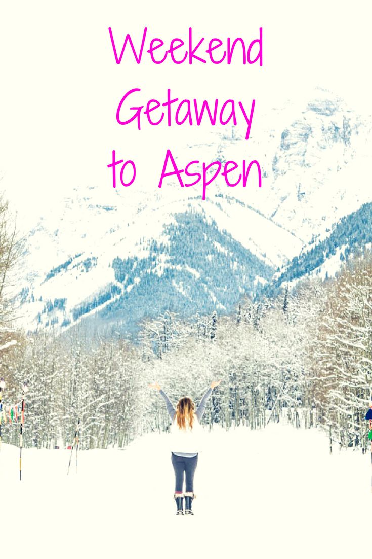 a woman is standing in the snow with her arms spread out and mountains behind her