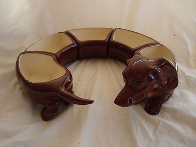 a brown elephant shaped vase sitting on top of a white tablecloth covered bedding