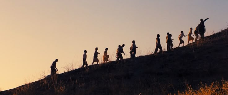 a group of people walking up the side of a hill