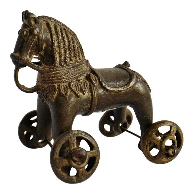 an old fashioned metal toy horse with wheels