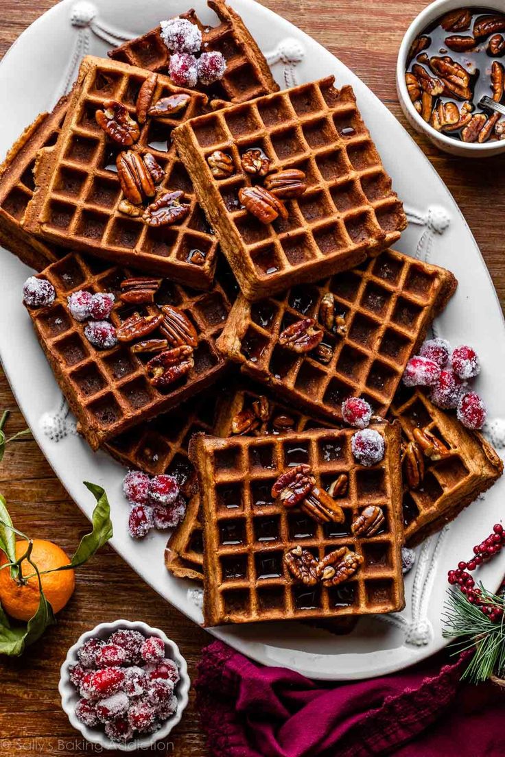 several waffles on a plate with cranberries and pecans