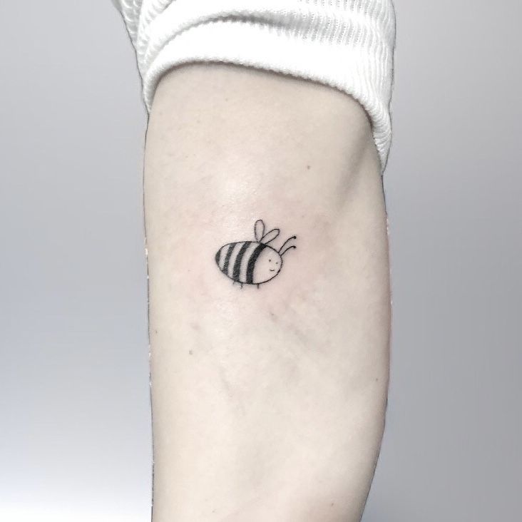 a black and white bee tattoo on the left inner side of the right arm,