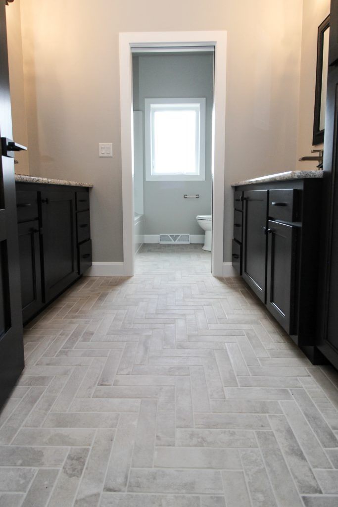 an empty kitchen with black cabinets and white tile flooring in the center is shown