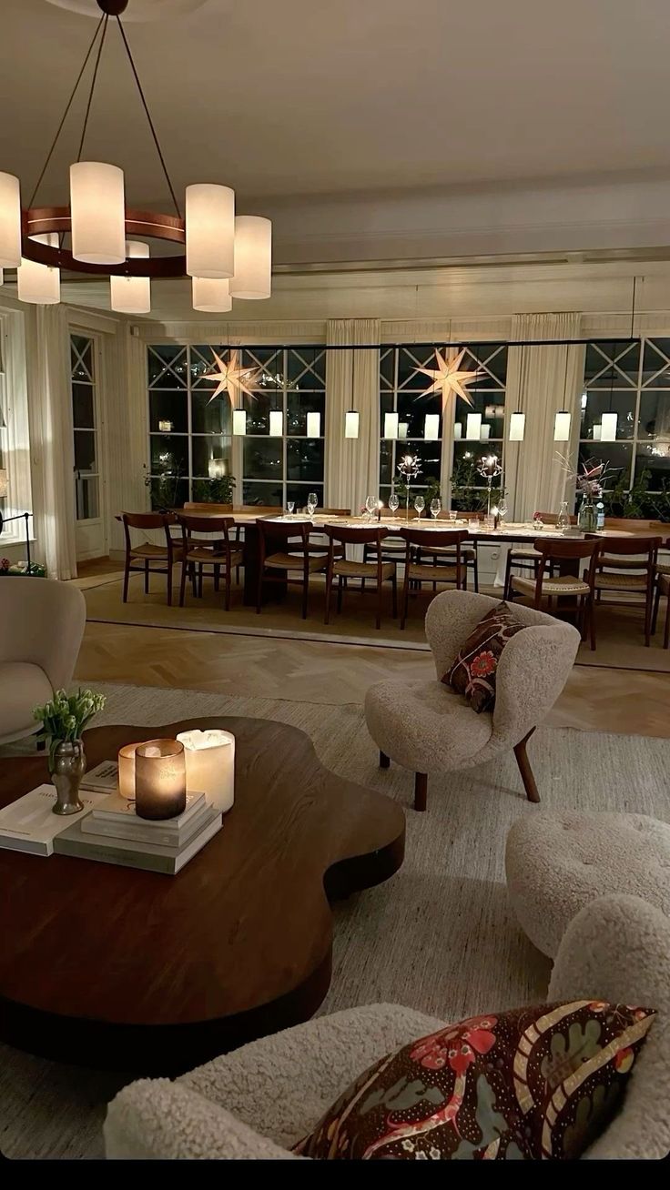 a living room filled with furniture next to a window covered in lots of windows and lit candles