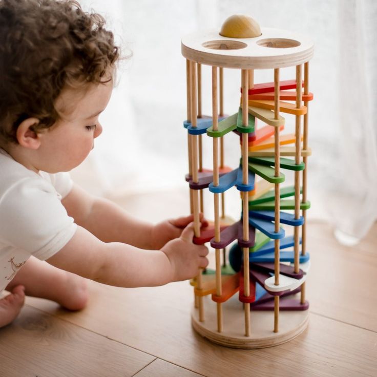 a small child playing with a toy tower