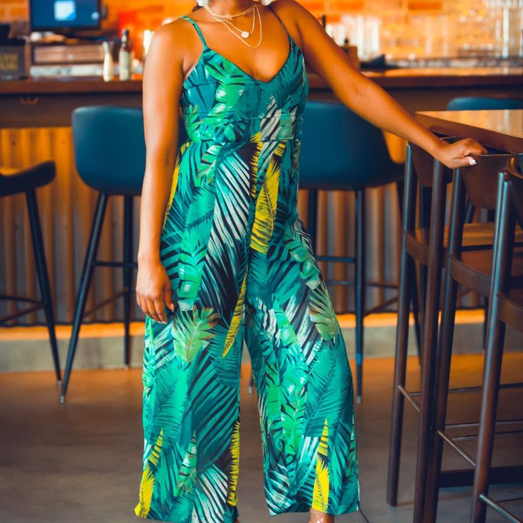 Transcend Yourself Onto Tropical Beaches With This Gorgeous Jumpsuit In A Vibrant Palm Leaves Print. With Many Shades Of Green, The Print Has A Summery Vibe But Can Work In Any Season, Thanks To The Dark Undertones. The Sweetheart Neckline With Narrow Straps And Wide Legs Make It A Timeless Piece That You Can Style Your Own Way. Sweetheart Neckline Narrow Straps Empire Waist Wide Legs Tropical V-neck Printed Jumpsuits And Rompers, Printed Tropical V-neck Jumpsuits And Rompers, Beach V-neck Jumpsuits And Rompers With Tropical Print, Beach V-neck Jumpsuit With Tropical Print, Green Tropical V-neck Jumpsuits And Rompers, Tropical Print V-neck Jumpsuits And Rompers For Beach, V-neck Tropical Print Jumpsuits And Rompers For Beach, V-neck Tropical Print Jumpsuit For Beach, Green V-neck Tropical Print Jumpsuits And Rompers