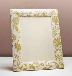 a white and gold frame sitting on top of a table