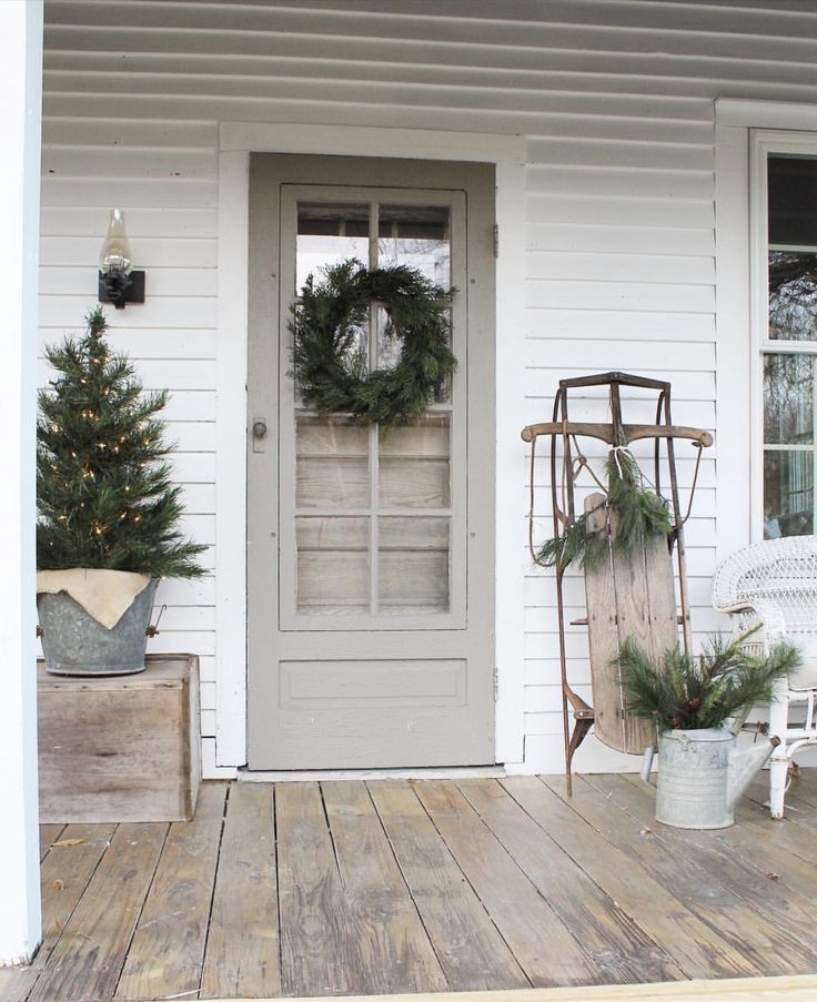 the front porch is decorated for christmas with wreaths