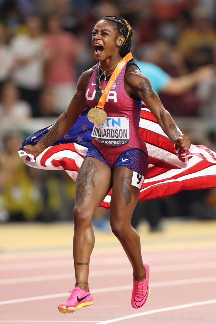 a woman running with an american flag on her lap and one foot in the air